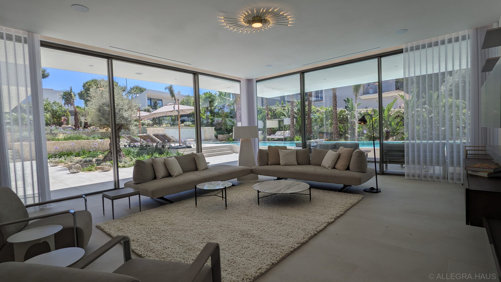 ALLEGRA Wohnzimmer mit Kamin, raumhohen Schüco-Fensterfronten und Blick auf den Pool ALLEGRA Wohnzimmer mit Kamin, raumhohen Schüco-Fensterfronten und Blick auf den Pool